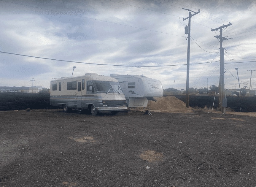 Boats on trailers and travel trailers share wide gravel aisles.